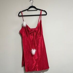 Red satin slip dress featuring white polka dots and fluffy feather trim.